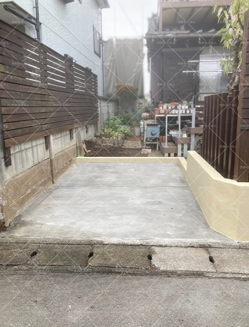 *平塚市の駐車スペースリフォーム後。新しいワイヤーメッシュ入りコンクリート舗装とジョリパット仕上げのブロック塀でスッキリした印象の外構。